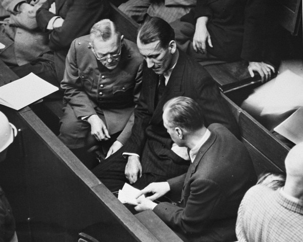 Defendants Wilhelm Keitel (left), Ernst Kaltenbrunner (middle), and Alfred Rosenberg (right), talk during a recess in the proceedings ...