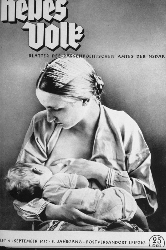 A mother with light skin tone breastfeeds her child. Her hair is pinned up and her shirt is open. One hand holds the child, the other positions her breast for feeding.